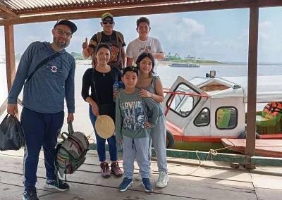 Passengers posing near boat in the Amazon