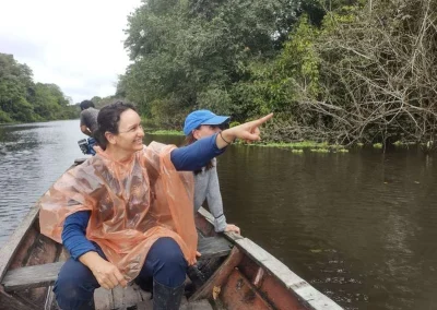 Traveler pointing at trees from the boat