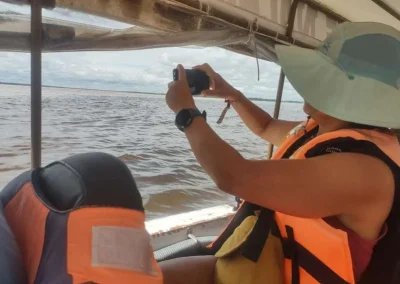 Traveler taking a photo of the river from the boat